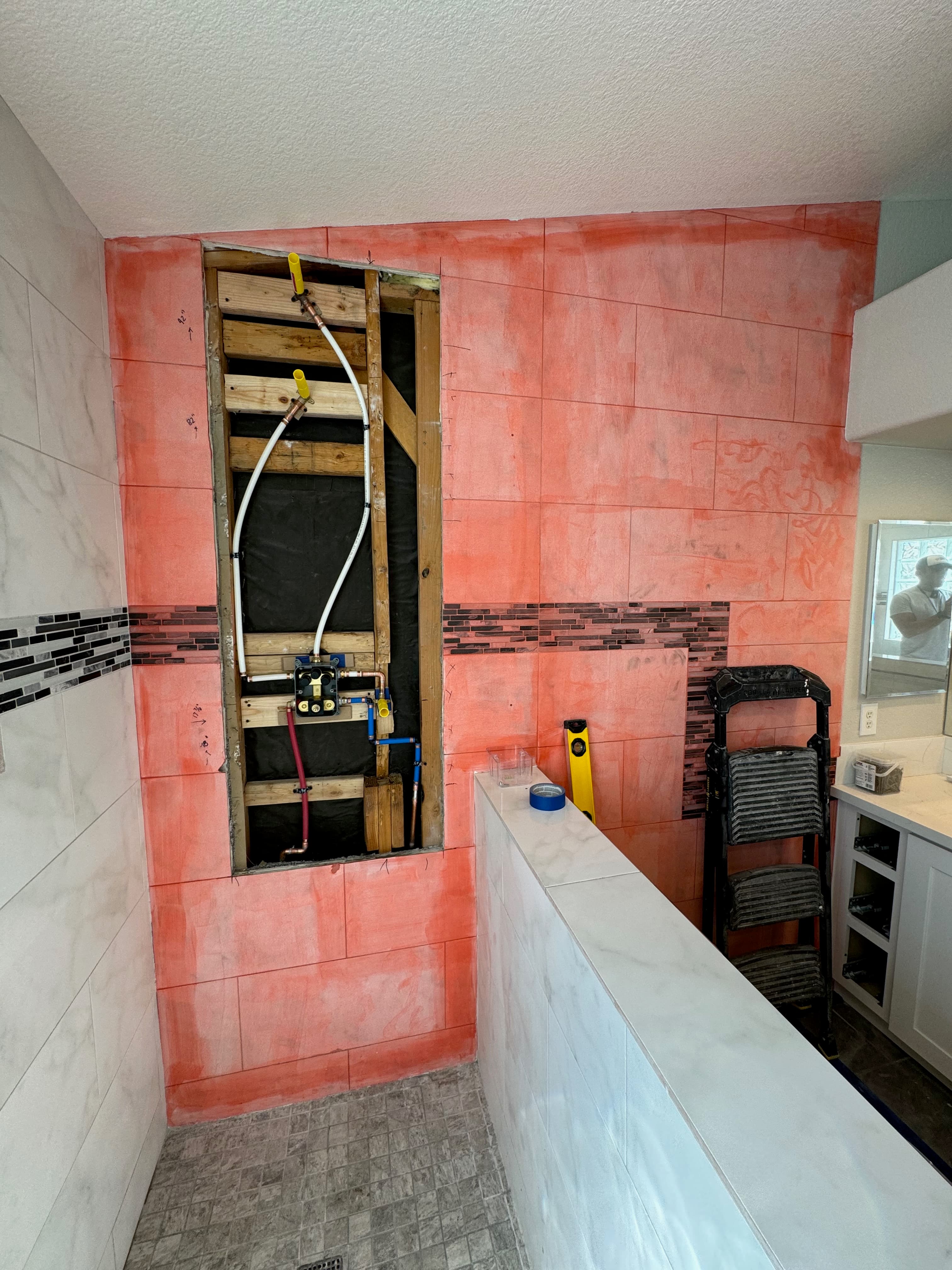 Waterproof membrane and plumbing rough-in before tile